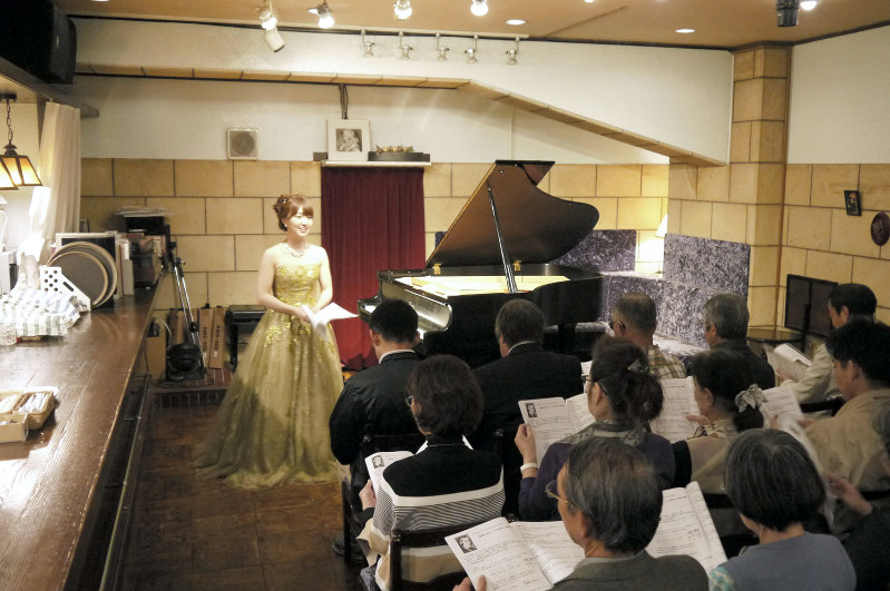 演奏前に曲の解説をする安達萌さん=神戸市中央区のアマデウスで、田中博子撮影