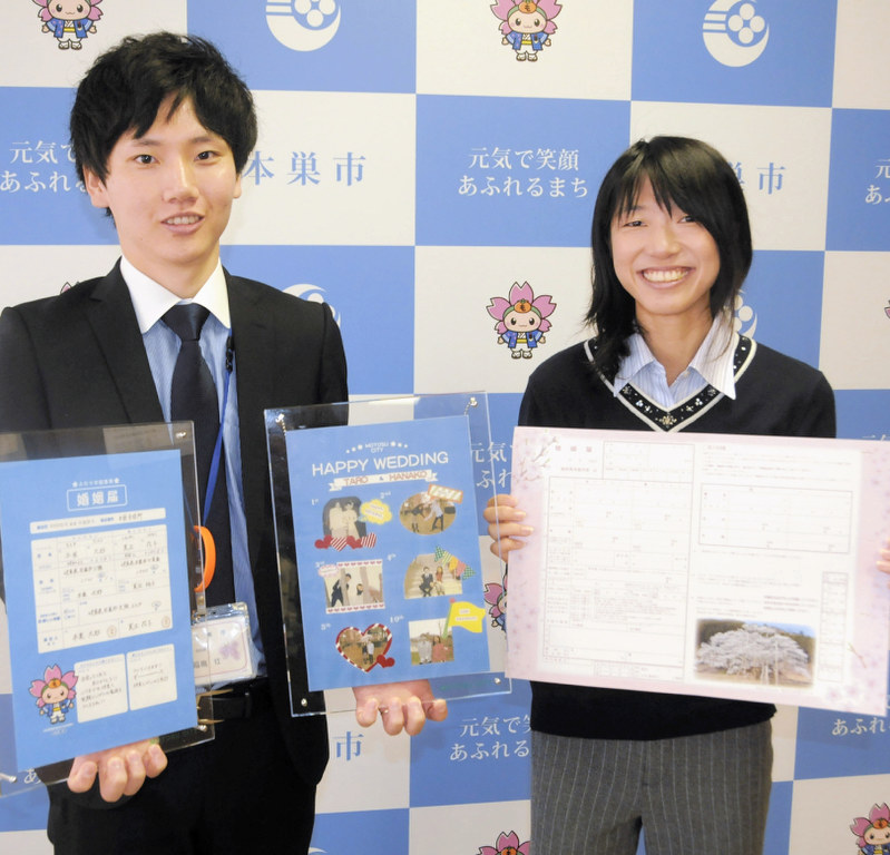 本巣市独自のオリジナル婚姻届(右)とフレームを紹介する市職員=同市役所で、立松勝撮影