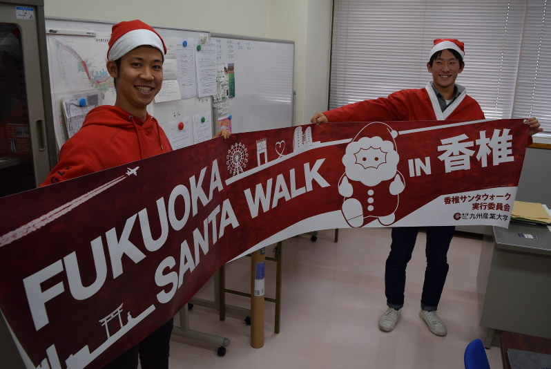 サンタウオークで使う横断幕を手にする実行委の九産大生