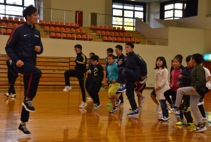 小学生に走り方のコツなどを指導する藤光選手(左端)
