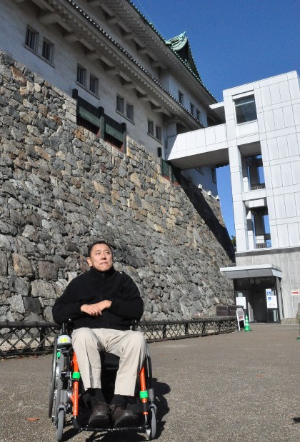 名古屋城が木造復元された際にはエレベーターを設置するよう求めた辻直哉さん。右奥は現在設置されている外部エレベーター＝名古屋市中区の名古屋城で２０１７年１１月２１日、三上剛輝撮影