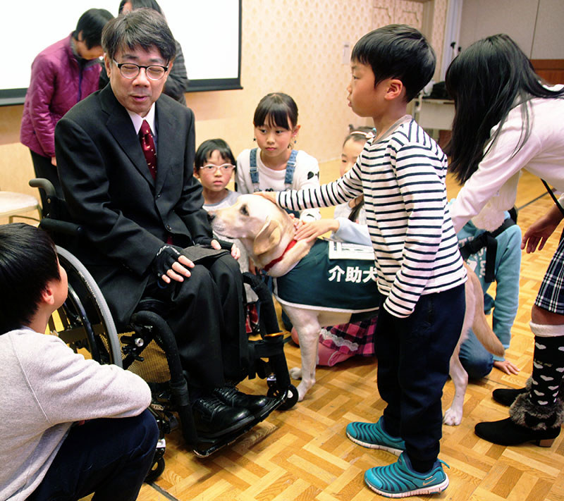 講演と実演の終了後、介助犬と触れ合う時間を取り、子どもらの質問に答える木村佳友さん=大阪市天王寺区の府教育会館で、高尾具成撮影