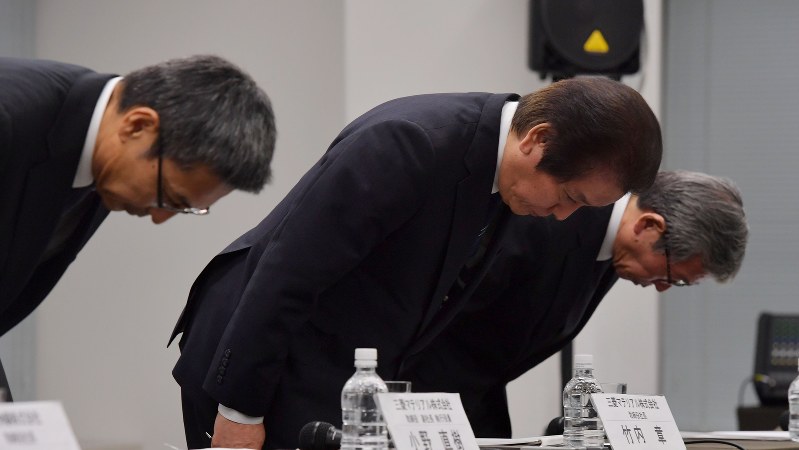 記者会見の終わりに頭を下げる三菱マテリアルの竹内章社長(中央)=2017年11月24日、西本勝撮影