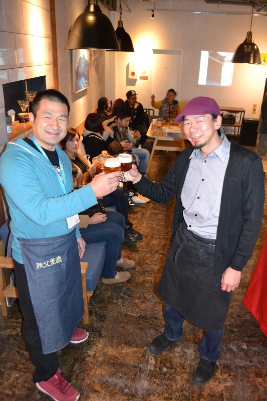 秩父麦酒のデビューを祝い、乾杯する醸造者の丹広大さん(左)とビール店オーナーの坪内純二さん=同市番場町のクラフトビール店「まほろバル」で
