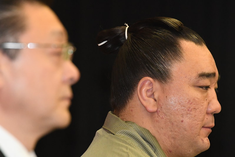 引退表明の記者会見でうつむく日馬富士関。手前は伊勢ケ浜親方=福岡県太宰府市で2017年11月29日午後2時20分、上入来尚撮影