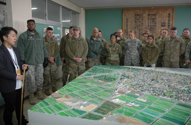 震災前の荒浜地区を再現した模型の説明を聞く米軍兵士ら=仙台市若林区の旧荒浜小で