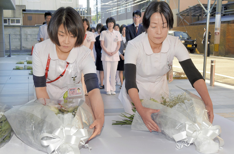 タクシー暴走事故から1年を前に現場の献花台に花を供える原三信病院の看護師ら=福岡市博多区で2017年12月2日午前8時58分、上入来尚撮影