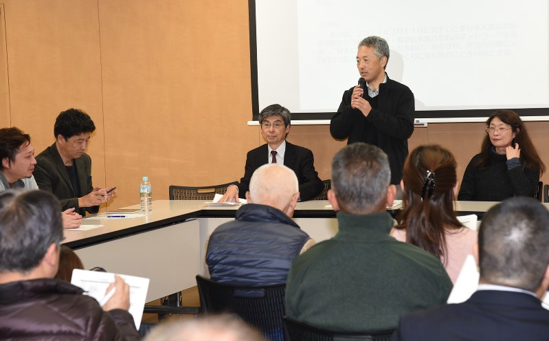 3.11メモリアルネットワークの代表に決まり、会員の前であいさつする鈴木典行さんと役員ら=石巻市で