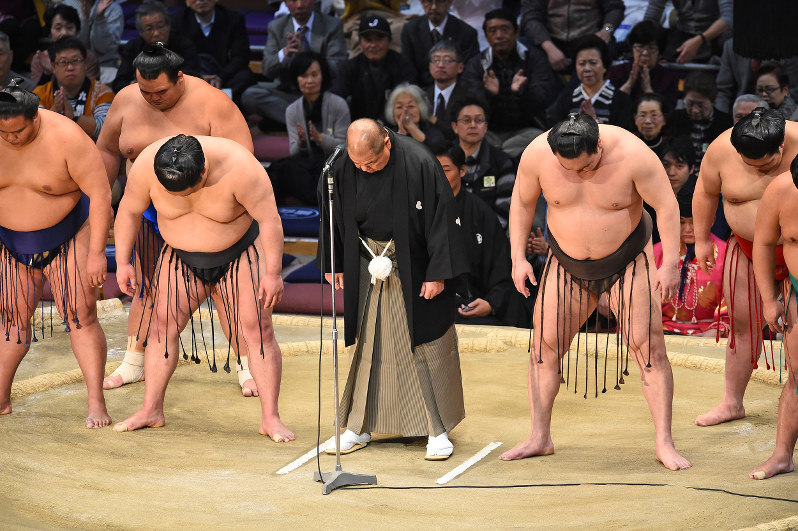 九州場所の千秋楽、土俵上で頭を下げる日本相撲協会の八角理事長(中央)ら=福岡国際センターで11月26日、矢頭智剛撮影
