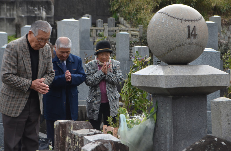 背番号「14」を刻んだ石碑のある沢村栄治氏の墓には今も多くの人が訪れる。右端が墓守をしてきた西村則子さん=三重県伊勢市の墓地で2017年3月、小沢由紀撮影