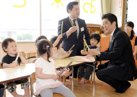 待機児童対策が無償化よりも先だという声は多い。安倍晋三首相（右端）は、保育所を視察したことはあるのだが……