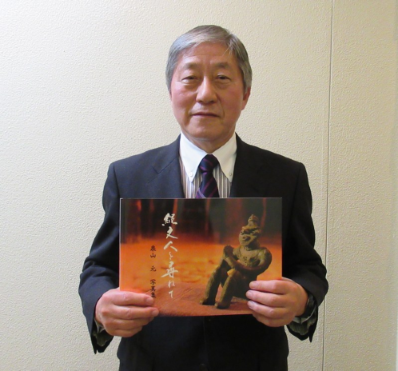 写真集を手にする泉山元さん=八戸市で