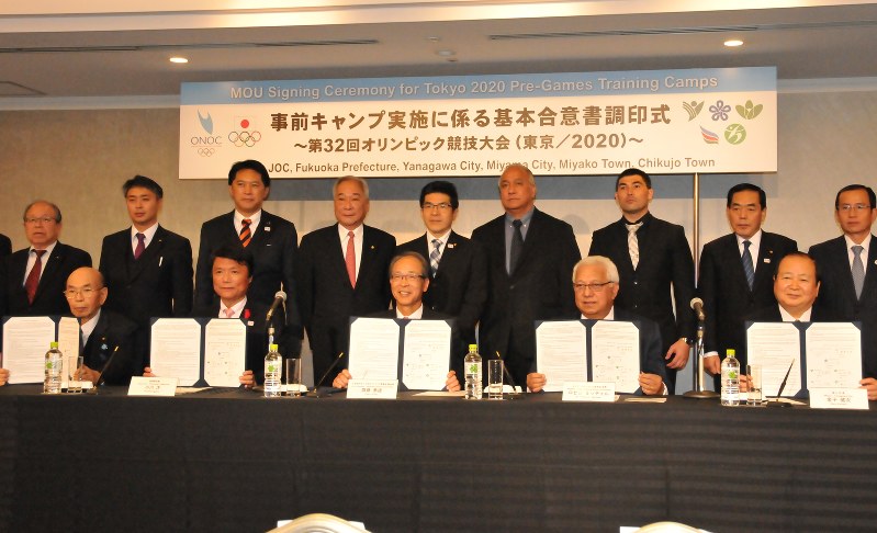 合意書を手に記念撮影する関係者(左端は西原親・みやま市長、右端は金子健次・柳川市長)