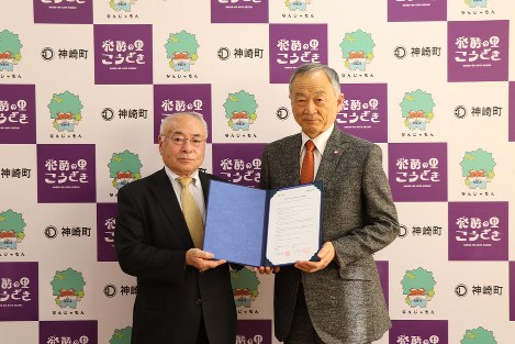 調印書を手にする石橋輝一町長と三幣利夫学長