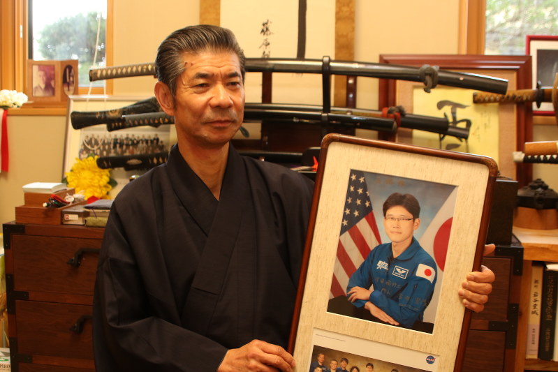金井宣茂さんの写真を手にする五戸敏明さん=青森県八戸市で2017年12月15日、塚本弘毅撮影