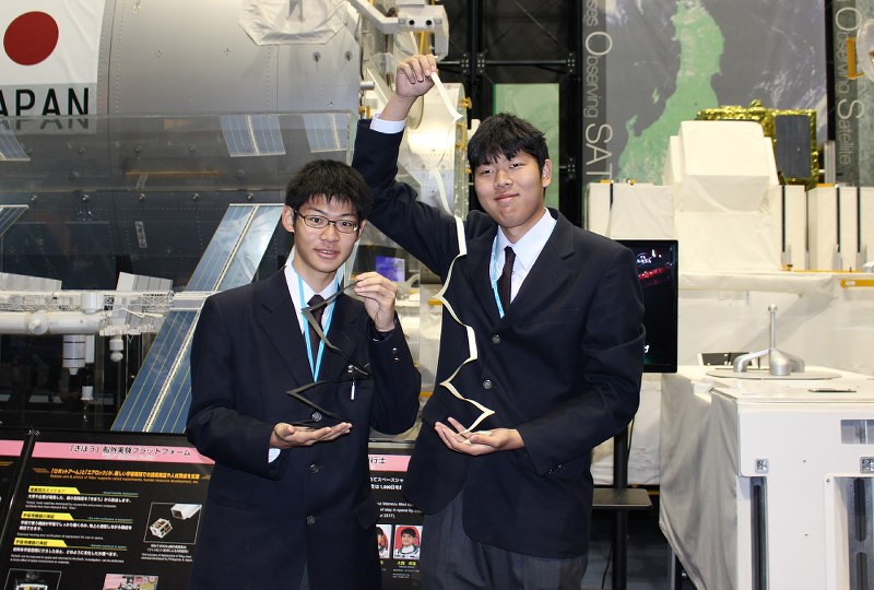 「紙バネ」を手にする並木中等教育学校の藤田さん(左)と十川さん=茨城県つくば市で17日、大場あい撮影