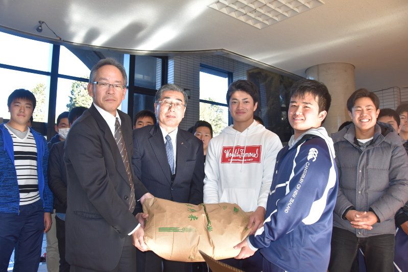 JAみなみ信州から米を贈られた飯田高の選手ら=飯田市上郷黒田の飯田高校で