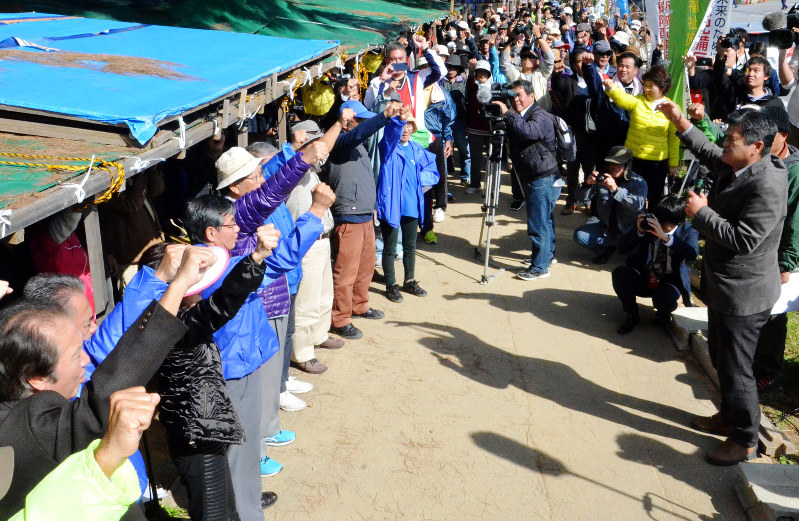 辺野古への移設阻止に向けて「頑張ろう」と声を上げる抗議集会の参加者=沖縄県名護市辺野古の米軍キャンプ・シュワブのゲート前で26日午後1時10分