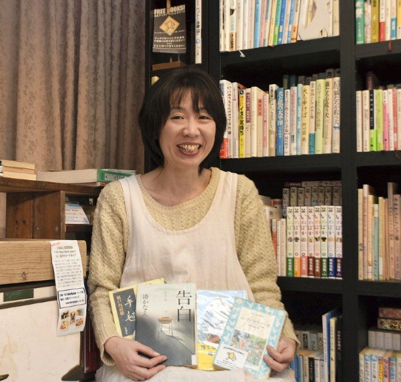 「自分の愛読書が誰かに渡って読まれているのは、うれしいしわくわくする」と笑う岡田くみこさん=広島市西区で