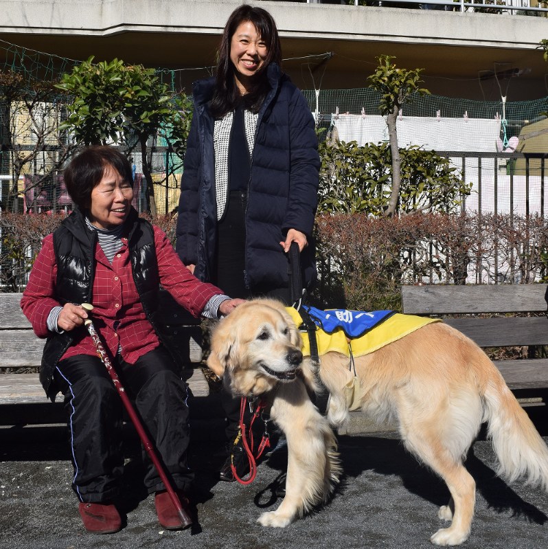 外での歩行訓練に同行した小嶋さん(右)とウィッシュ=いずれも川崎市高津区で
