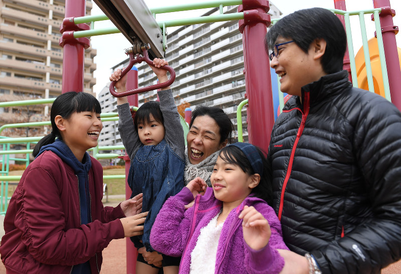 被災した自宅の跡地に整備された公園で家族と遊ぶ新川愛さん(中央)=神戸市長田区で2017年12月16日、久保玲撮影