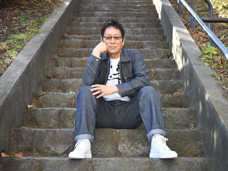 階段に腰掛けて自然体のポーズ。「何事も面倒くさがらずに腰を上げると、面白いことはたくさんある」=東京都千代田区で、中村藍撮影