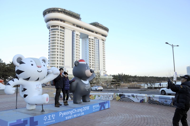 平昌五輪マスコット像の前で記念写真を撮る観光客。背後では、高層ホテルの建設が急ピッチで進んでいた=韓国・江陵市で2017年12月、神足俊輔撮影