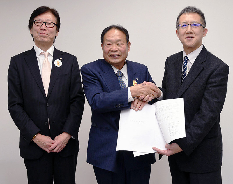 公害防止協定を締結して握手する小出隆道・上富田町長(中央)とグリーン・サーマルの滝沢誠社長(右)、大和PIパートナーズの高橋昭夫会長=和歌山県上富田町役場で、藤田宰司撮影
