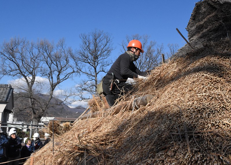 かやぶき屋根の修理をする職人=笛吹市で