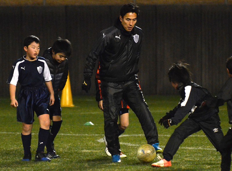 サッカースクールの生徒とともにボールを蹴る長谷部