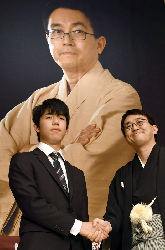 竜王就位式を前に握手する羽生善治竜王(右)と藤井聡太四段=東京都渋谷区で16日午後、根岸基弘撮影