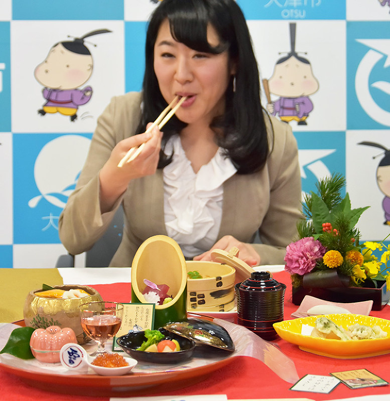 琵琶湖ホテルが販売している百人一首メニュー。奥は試食する大津市の越直美市長=同市役所で、衛藤達生撮影