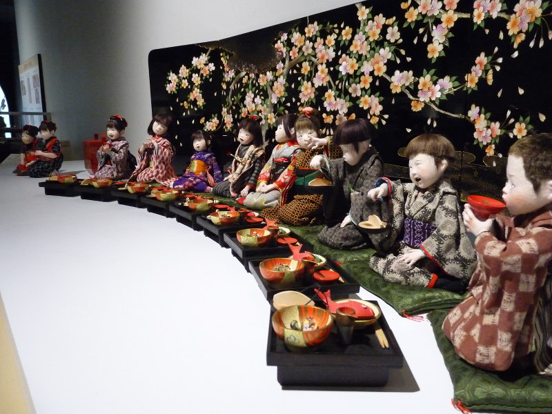昭和の世相を浮き彫りにした水澄美恵子さんの人形作品「めでたい日」=四日市市立博物館で