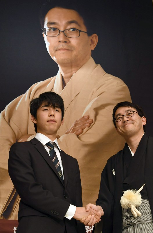 竜王就位式を前に握手する羽生善治竜王（右）と藤井聡太四段＝東京都渋谷区で１６日午後、根岸基弘撮影