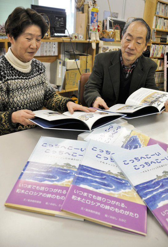 出来上がった絵本を広げる実行委の五十嵐百合子会長(左)ら=島根県江津市人権啓発センターで2018年1月16日、関谷徳撮影