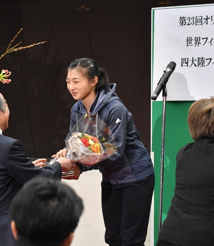 兵庫県スケート連盟主催の壮行会で花束を受け取る坂本花織選手。報道陣にも公開されたが所属先が分からない服装で臨んだ=神戸市中央区で2018年1月11日、米山淳撮影