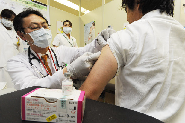 インフルエンザワクチンの接種を受ける男性=東京都内の国立病院で2010年2月10日、代表撮影
