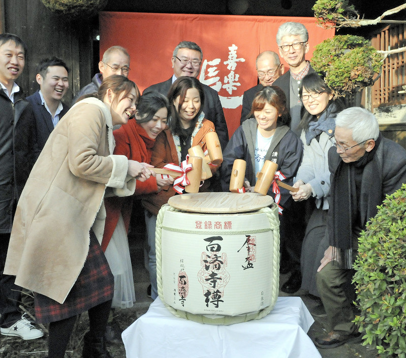 稲刈りから協力してきたオーナーたちと「百済寺樽」の鏡割りをする比嘉さん(前列右から3人目)=滋賀県東近江市池田町の喜多酒造で2018年1月20日、金子裕次郎撮影