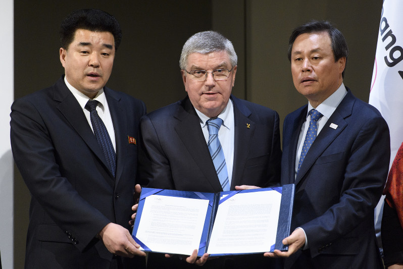 署名した書類を手にする(左から)北朝鮮オリンピック委員会の金日国委員長、IOCのバッハ会長、韓国の都鍾煥・文化体育観光相=2018年1月20日、AP