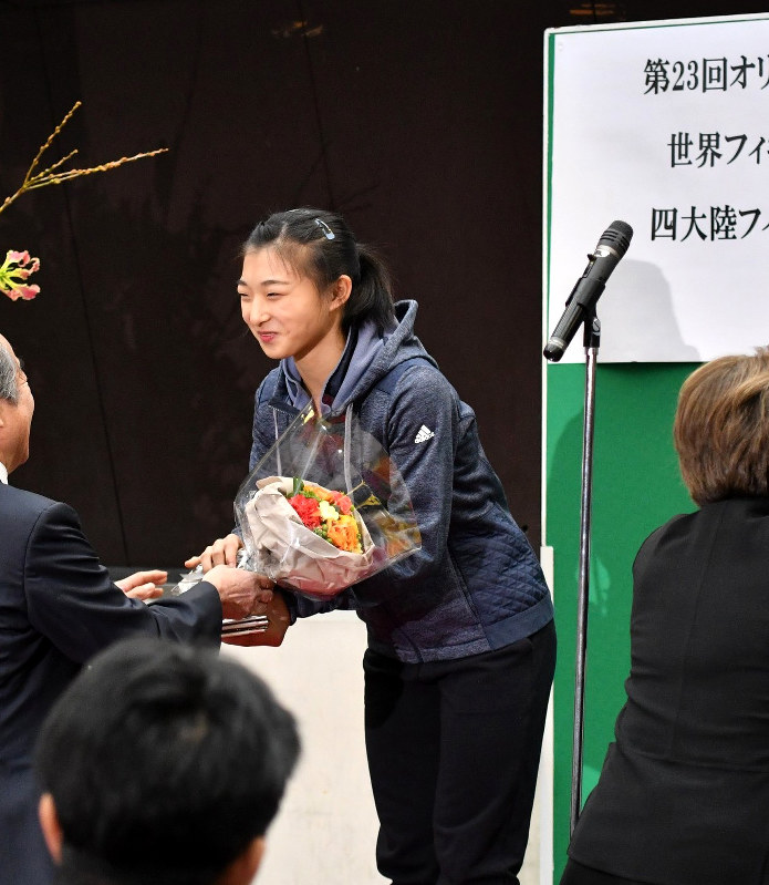兵庫県スケート連盟主催の壮行会で花束を受け取る坂本花織選手。報道陣にも公開されたが所属先が分からない服装で臨んだ=神戸市中央区で11日、米山淳撮影