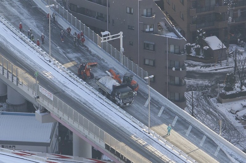 大雪の影響で通行止めとなった首都高7号線で行われた除雪作業=東京都墨田区で2018年1月23日午前7時58分、本社ヘリから