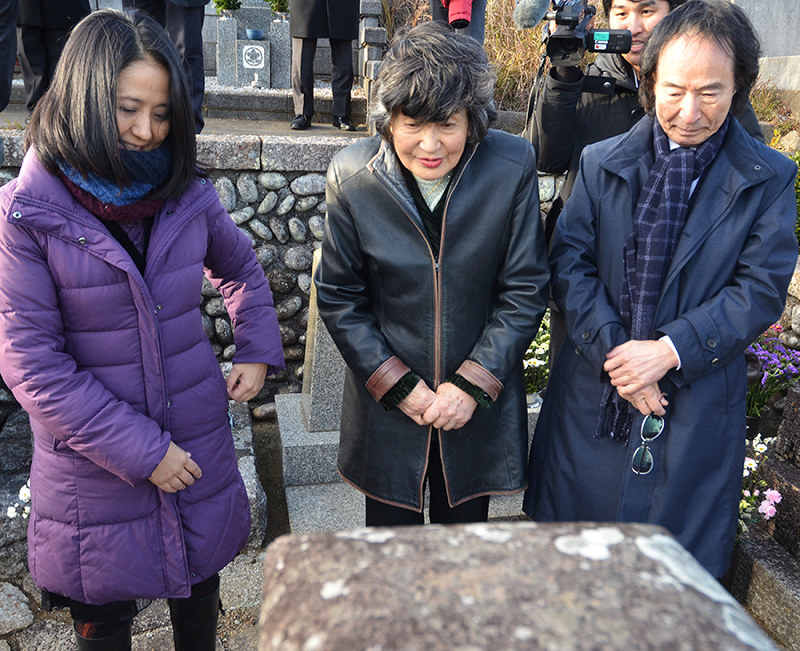 大石誠之助の墓前で名誉市民決定を報告する(左から)立花万起子さん、立花利根さん、辻原登さん=和歌山県新宮市の市営南谷墓地で、神門稔撮影