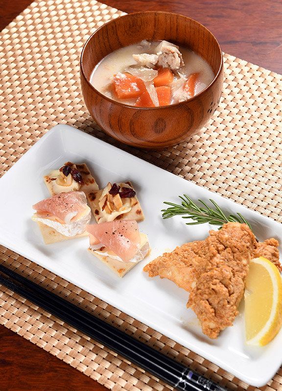 手前のお皿は、おしゃれな雰囲気の(左から)焼き酒かすのカナッペと酒かす入りタンドリーチキン風。奥は定番のかす汁。体もぽかぽか温まる=京都市伏見区の月桂冠総合研究所で、小松雄介撮影