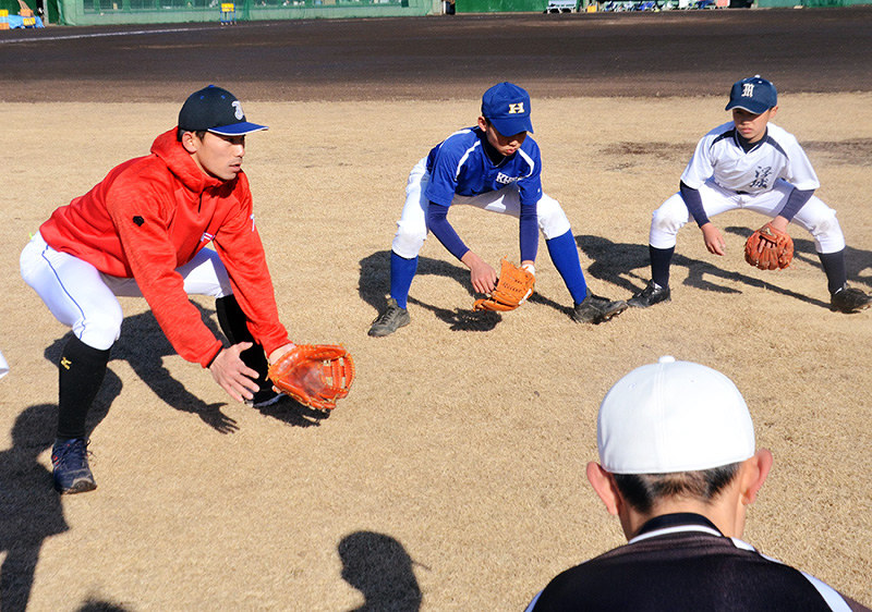 ゴロ捕球のポイントを教えるJFE西日本の岡将吾選手(左)=広島県福山市で、真下信幸撮影