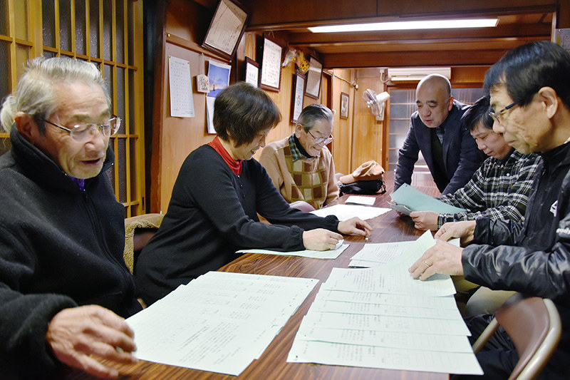集まった署名を確認する白玉会の役員らと安孫子邦夫さん(右奥)=大津市中央2で、衛藤達生撮影