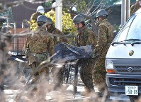 墜落現場から陸自ヘリコプターのものと見られる部品を運び出す自衛隊員＝佐賀県神埼市で２０１８年２月６日午前１０時１８分、徳野仁子撮影