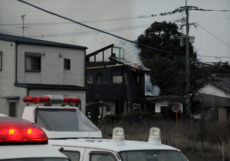 ヘリの墜落が原因と見られる火災で煙を上げて燃える民家=佐賀県神埼市で2018年2月5日午後5時49分、石井尚撮影
