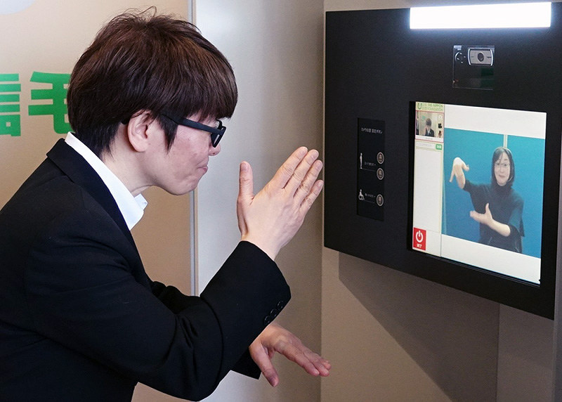 画面のオペレーターに手話で話しかけ、相手先とやり取りできる聴覚障害者向け公衆電話「手話フォン」=兵庫県明石市大明石町1のあかし市民広場で2018年2月5日、浜本年弘撮影