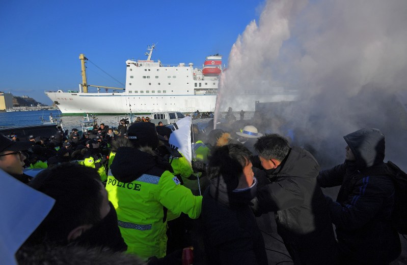 反対派に向かって警察が消火器を噴射する中、入港する万景峰92号=韓国・東海市の墨湖港で2018年2月6日午後4時35分、手塚耕一郎撮影
