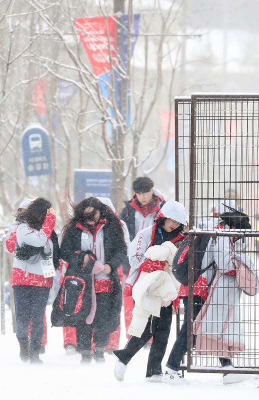 雪が舞う中、活動する平昌五輪のボランティアら=韓国・平昌で2018年2月3日、佐々木順一撮影